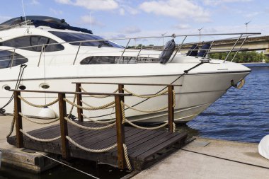 Yat nehir kenarında bir ahşap köprü iskelede palamarla. Fram parçası