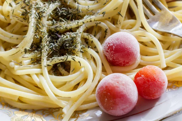 盘子里有意大利面和冷冻西红柿 框架的一部分 — 图库照片