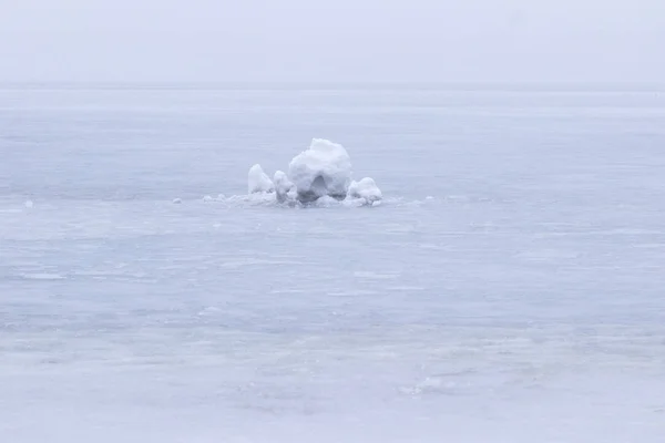 A lump of snow among the frozen river. Foggy — Stock Photo, Image