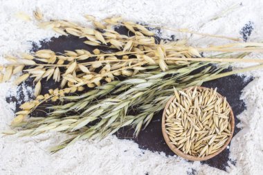 Spikelets yulaf ve tahıl dökülmüş un üzerinde ahşap kase. 