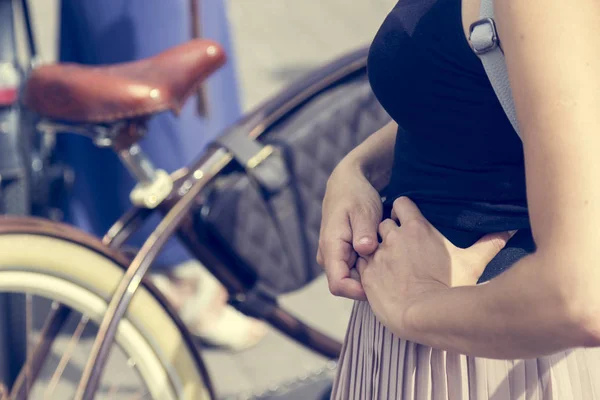 Conceito: mulheres de bicicleta. A menina segura as mãos na cintura, perto da bicicleta. Parte da imagem — Fotografia de Stock
