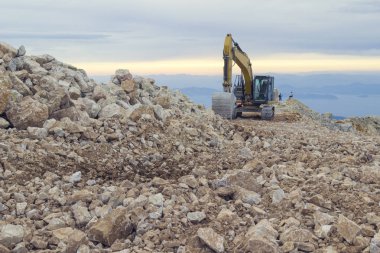 Büyük büyüklükte ki paletli ekskavatör, açık havada taş çıkaran