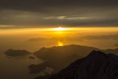 Dağlar ve deniz, gün batımı, pastel renklerde gökyüzü, ışık pus, bulanıklık