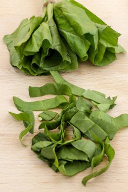 Kesme tahtasında dilimlenmiş yeşil ıspanak. Üstte görüntü