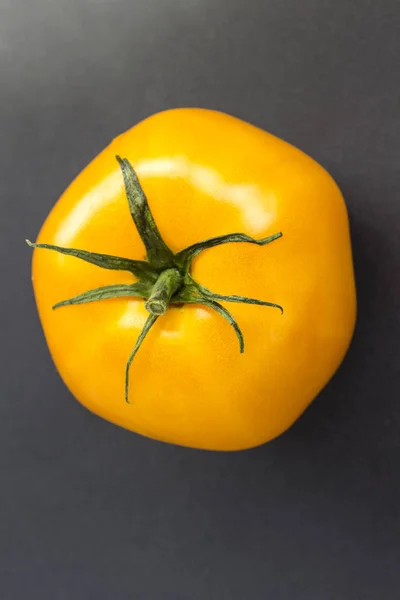 Gelbe Tomate auf schwarzem Hintergrund. Ansicht von oben — Stockfoto