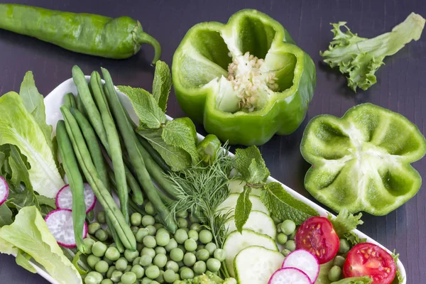 El juego de hortalizas: los guisantes, el pimiento verde, los rábanos, el pepino. Fondo negro — Foto de Stock