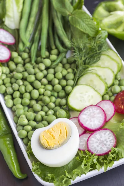 Satu set sayuran dengan telur: kacang polong, lada hijau, lobak, mentimun. Latar belakang hitam — Stok Foto