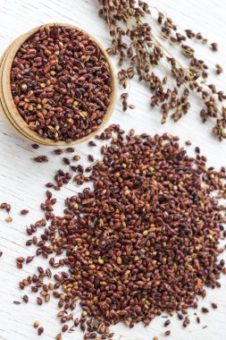 Beyaz arka plan üzerinde kırmızı darı ve darı taneli kutu