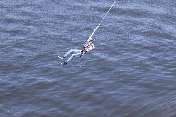 Een extreme man springt op een touw van een grote hoogte. Ropejumpen. — Stockfoto