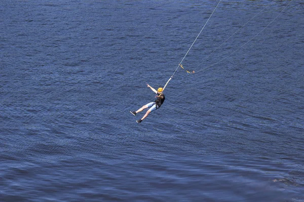 Aşırı bir adam bir ip üzerinde büyük bir yükseklikte atlar. Ropejumping. — Stok fotoğraf