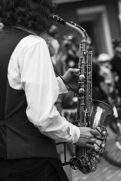 Manos de músico callejero tocando el saxofón en un entorno urbano — Foto de Stock