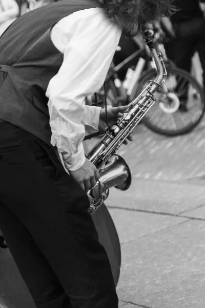 Mãos de músico de rua tocando saxofone em um ambiente urbano — Fotografia de Stock
