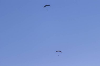 Mavi gökyüzüne karşı iki paraşütçü