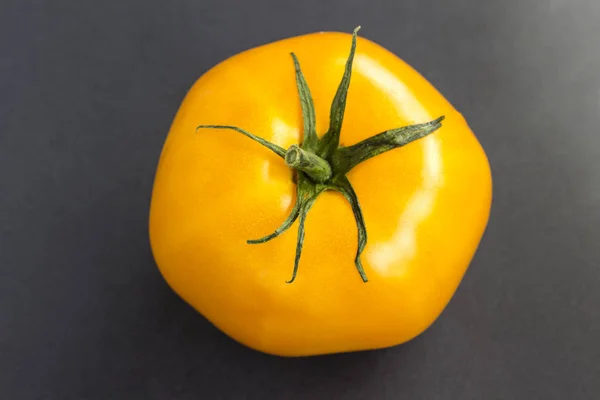 Gelbe Tomate auf schwarzem Hintergrund. Ansicht von oben — Stockfoto