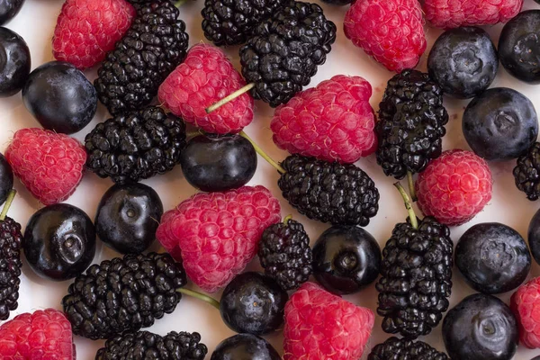 Berries: raspberries and blueberries, blackberries on a white plate. Close-up — Stock Photo, Image