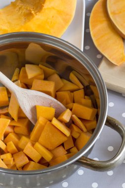 Kabak çorbası pişirme için hazırlık, bir tavada doğranmış kabak ve bir kesme tahtası üzerinde