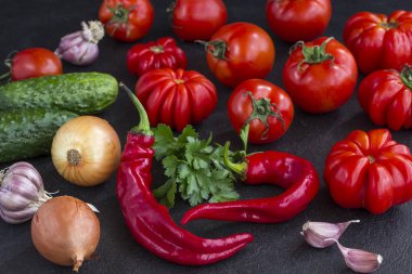 Siyah bir arka plan üzerinde sebze seti: domates, salatalık, biber, sarımsak, soğan ve maydanoz