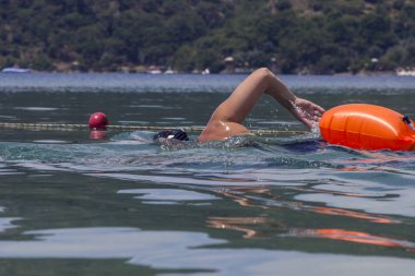 Bir adam denizde yüzüyor.