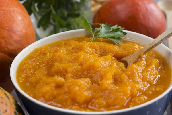 Pumpkin porridge in a bowl among orange pumpkins. Close-up — Stock Photo, Image