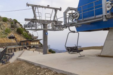 Güneşli bir yaz gününde boş bir teleferik. Dağ yamacı