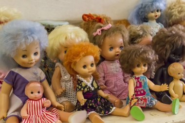 Mutlu çocukluk konsepti: retro oyuncaklar, çok renkli saçlı bebekler masada oturuyor