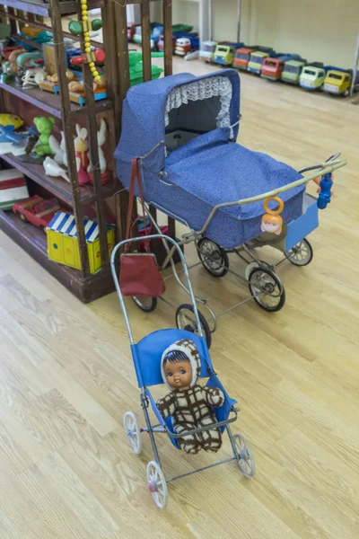 Happy koncepcja dzieciństwa: zabawki retro, lalka w wózku i zabawki samochodów w pokoju — Zdjęcie stockowe