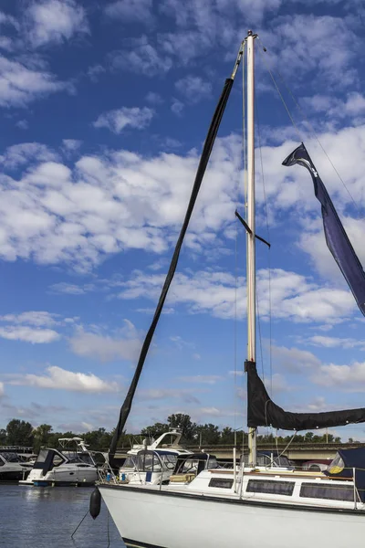 Mât avec voiles abaissées, sur l'avant du yacht une aile noire — Photo