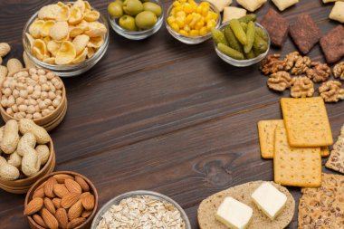 Balanced protein breakfast: jam yogurt cereal, orange juice, orange olives cookies butter. Dark wooden background. Close up. Flat lay