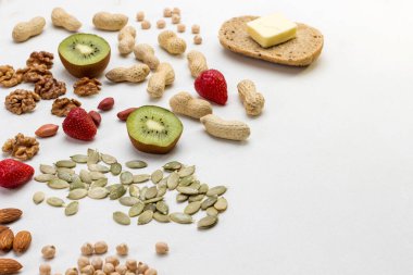 Kahvaltı hazırlamak için gerekli malzemeler: Fındık tohumlu tereyağı rulosu. Lezzetli ve sağlıklı yiyecekler. beyaz arkaplan, üst görünüm, kopyalama alanı