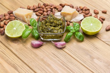 Ev yapımı pesto için malzemeler: fesleğen yaprağı, parmesan, çam fıstığı, sarımsak, yarım limon. Üst Manzara. Hafif ahşap arka plan. Boşluğu kopyala