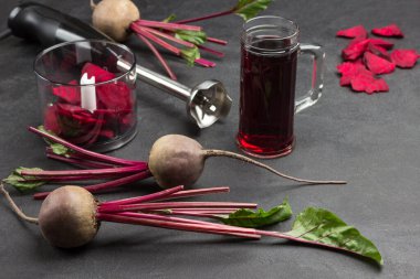 Üstü açık pancar, dilimlenmiş pancar. Bir bardak pancar suyu. Blender kavanozunda dilimlenmiş pancar. Kesici. Üst Manzara. Siyah arkaplan