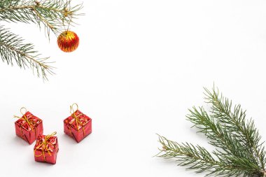 Noel zamanı. Kırmızı pakette üç hediye. Kırmızı top ladin dalında. Beyaz arka plan. Uzayı kopyala Düz yatıyordu