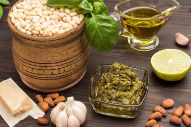Ev yapımı pesto için malzemeler: fesleğen yaprağı, parmesan, çam fıstığı, sarımsak, yarım limon. Karanlık ahşap arka plan. Üst görünüm