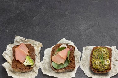 Bruschetta 'yı çeşitli malzemelerle karıştır. Kahverengi arka plan. Düz yatıyordu
