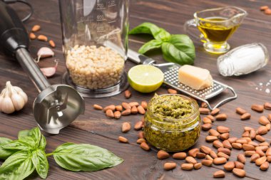 Pesto. Soyulmamış çam fıstığı, kavanozda pesto sosu rendelenmiş parmesan, sarımsak, fesleğen, çırpıcı, limon. Üst Manzara. Koyu renk ahşap