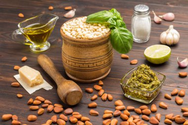 Ev yapımı pesto için malzemeler: fesleğen yaprağı, parmesan, çam fıstığı, sarımsak, yarım limon. Karanlık ahşap arka plan. Üst görünüm