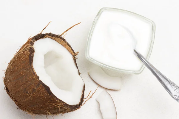 Half Verse Kokosnoot Een Kom Yoghurt Een Lepel Witte Achtergrond — Stockfoto