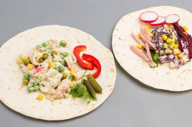 Vejetaryen salatasıyla sarılmış vejetaryen tortilla. Beyaz arka plan. Düz yatıyordu