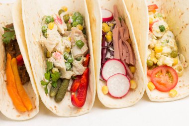 Cam kaselerde konserve mısır. Vejetaryen salatasıyla sarılmış vejetaryen tortilla. Beyaz arka plan. Seçici odak