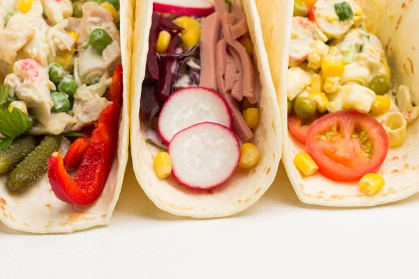 Vejetaryen salatasıyla sarılmış vejetaryen tortilla. Kapatın. Beyaz arka plan. Üst görünüm.