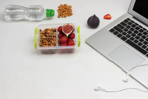 Lunchbox with nuts and fruits.  Bottle of water. Launch Box. White background. Copy space. Flat lay