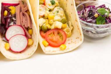 Tortilla salatayla sarılır. Kapatın. Beyaz arka plan. Üst görünüm.