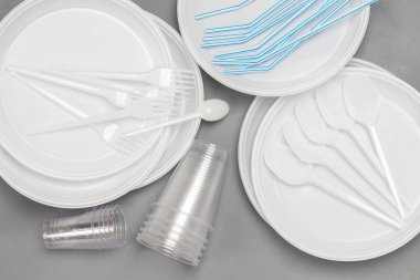 Tek kullanımlık plastik sofra takımı. Tabak, kaşık, çatal, pipet. Ekoloji çevresel bakım. Düz yatıyordu. Gri arkaplan