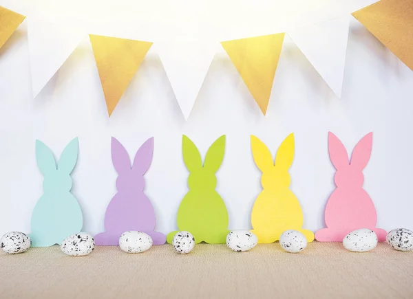 Påsk bakgrund med ägg, kaniner och girlander flaggor — Stockfoto