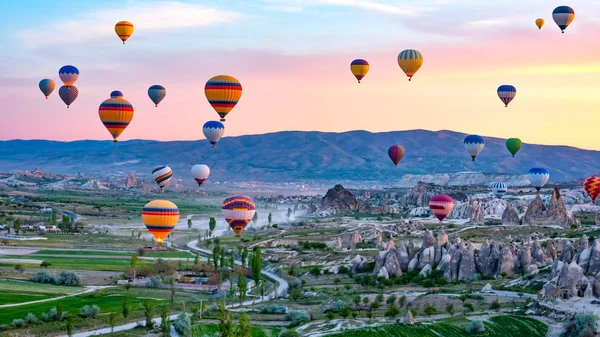 Kolorowe gorące powietrze balony latające nad opoka pejzaż w Cappadocia — Zdjęcie stockowe