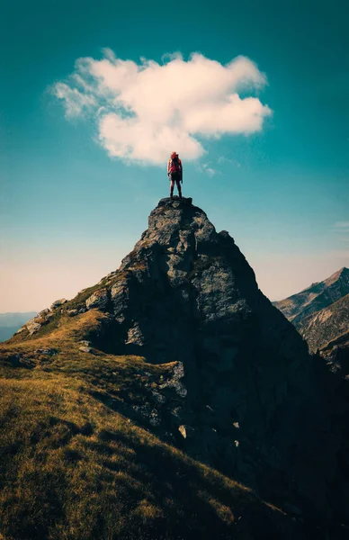 Yukarıdaki bir bulut ile bir dağ tepe üstüne uzun yürüyüşe çıkan kimse.