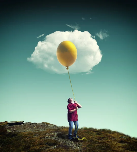 Jovem Levantando Balão Amarelo Para Uma Nuvem Parecendo Ovo Frito — Fotografia de Stock