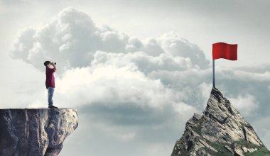 Adam bir kırmızı bayrak için dürbün üzerinden baktığımda bir dağ tepe üzerinde. Hedeflerine ulaşma kavramı.