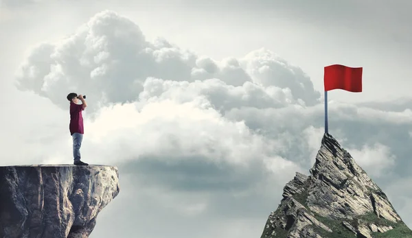 Adam bir kırmızı bayrak için dürbün üzerinden baktığımda bir dağ tepe üzerinde. Hedeflerine ulaşma kavramı.