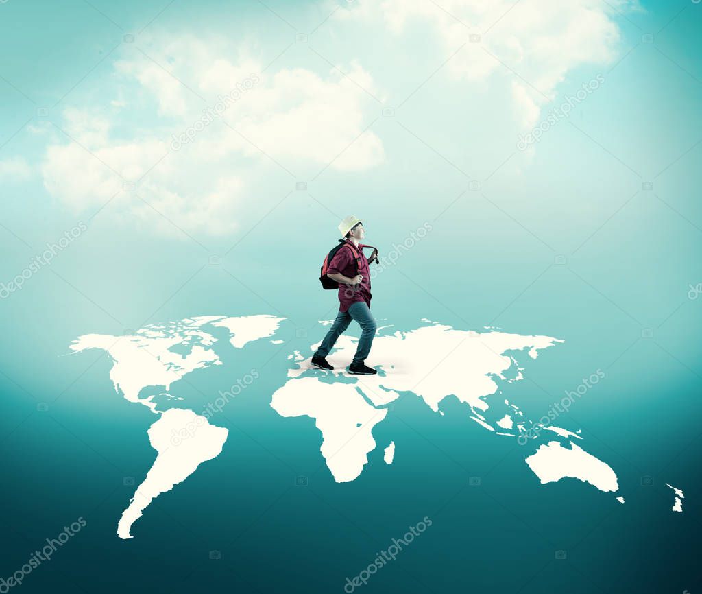 Excited traveler walks across world map.